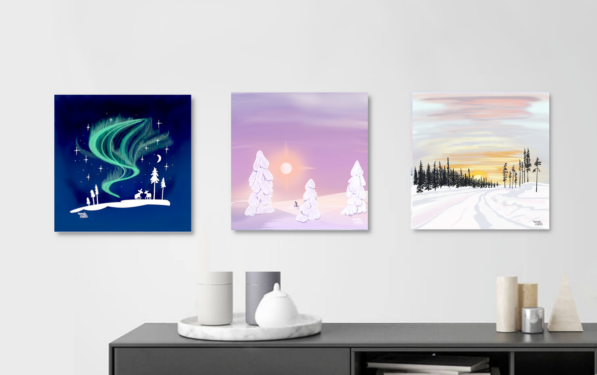 Three Nordic landscape illustrations, an aurora, a soft polar dawn and a golden winter forest, hung above a minimalist Scandinavian sideboard. Nordic wall art as a window onto the North, by Els Bancken, Aurealis Creatief.